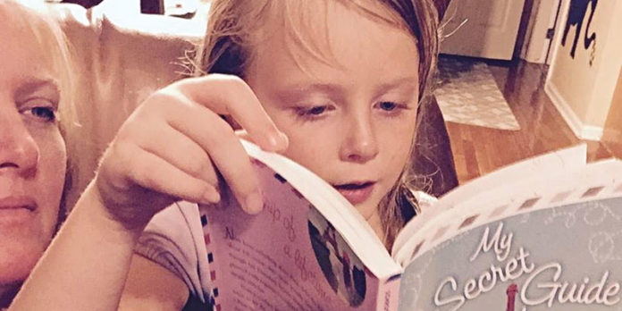 Caroline Sutton listening to her daughter Isabel read out loud for her homework reading assignment.