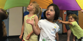 Kindermusik students enjoying parachute time during class with their instructor Jeanna Hoyt.