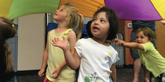 Kindermusik students enjoying parachute time during class with their instructor Jeanna Hoyt.