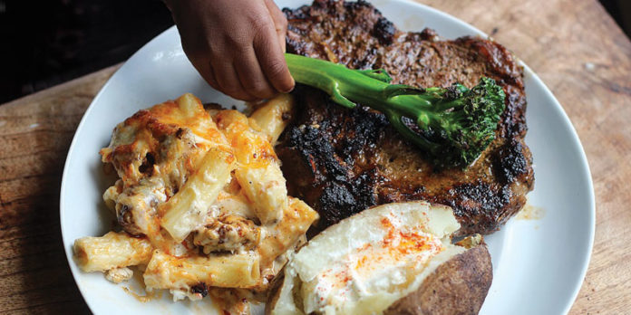 Steak, Baked Mac-n-Cheese, and Baked Potato with Brussels Sprout Garnish.