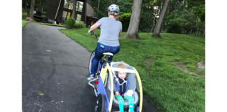 Courtney Stinson pulls Ellie in an adapted bike trailer.
