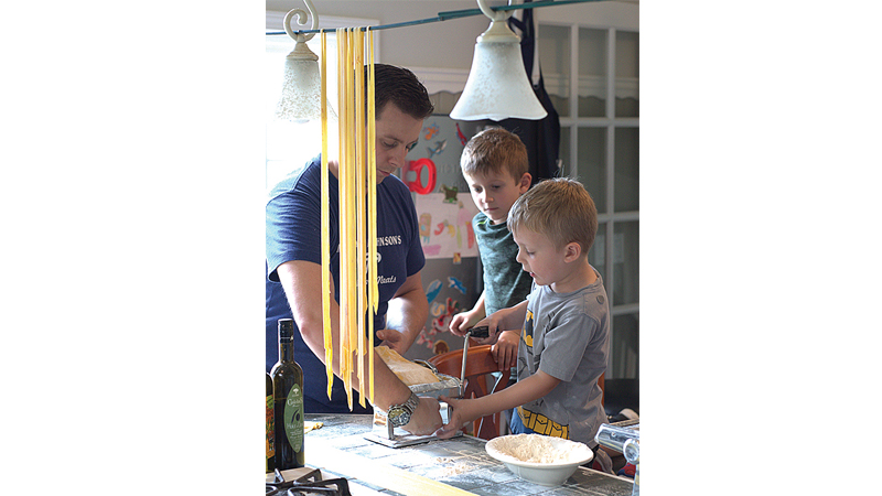 Chef Kieron Hales rolling pasta with his two boys, Henry and Owen. Photo Courtesy of Zingerman’s Cornman Farms