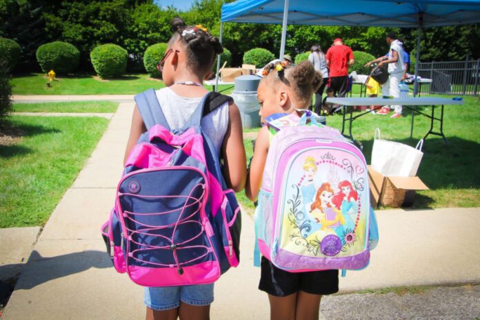 Two kids with backpacks on.