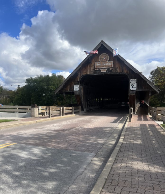 An older building or shelter by a bridge.