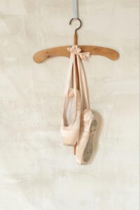 A photo of dance shoes hanging on a clothes hanger.