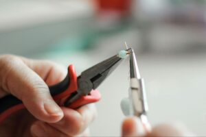 A photo of someone making jewelry.