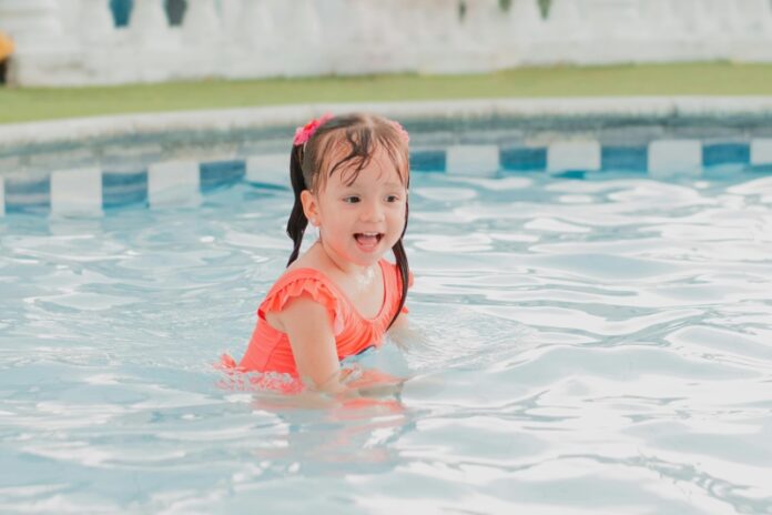 Young girl playing in swimming pool