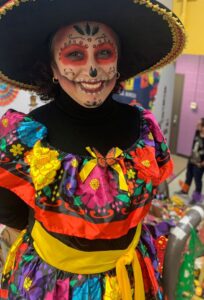 Parent dressed for Día de los Muertos event