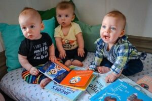 A photo of children sitting with books next to them.