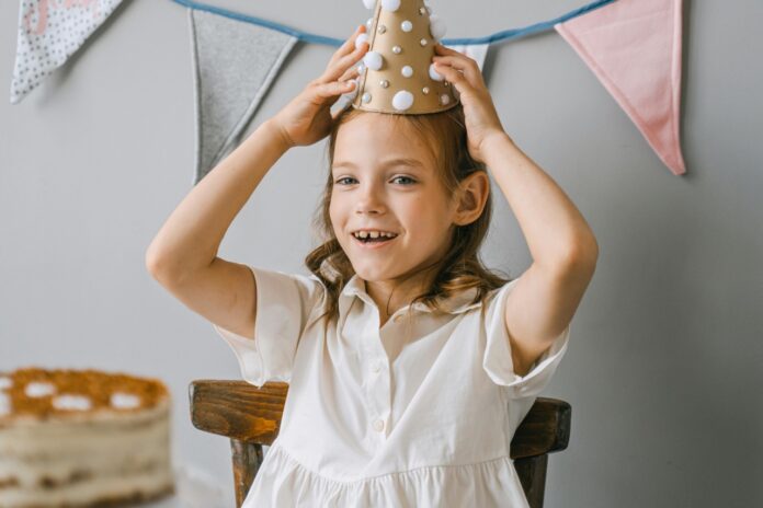 A photo of a child with a party hat on.