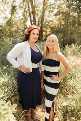 A parent standing with their child.