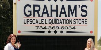 Two people standing by a sign.