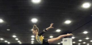 A child on a balance beam in a gymnastics class.