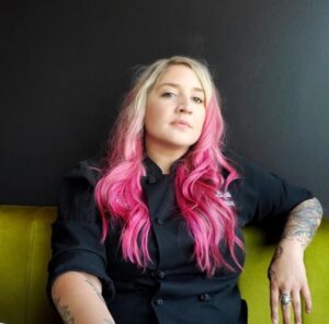 Woman with pink hair on green couch
