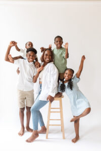 Photo of family posing on stool against white background