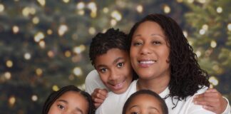 Photo of family in matching pajamas by Christmas tree