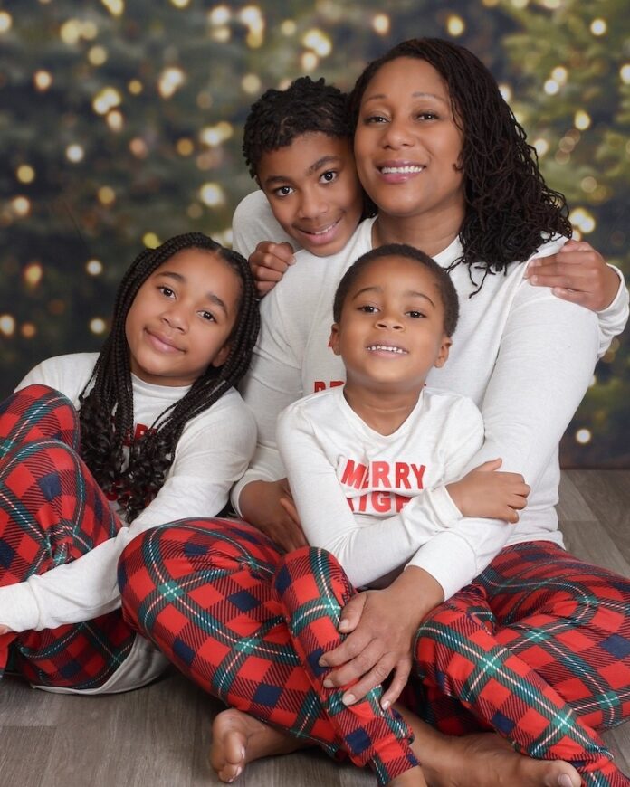 Photo of family in matching pajamas by Christmas tree