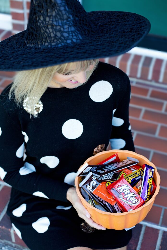 Woman holding bowl of full-size Halloween candy