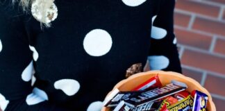 Woman holding bowl of full-size Halloween candy