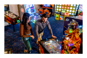 Man and woman at pinball machine