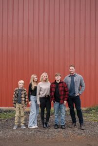 Family of five in front of red building