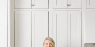 Woman sitting on kitchen counter with legs crossed