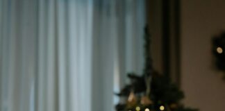 Sad woman at table by christmas tree