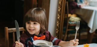 kids holding knife and fork at restaurant