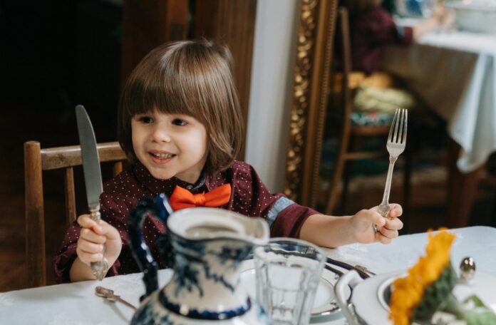 kids holding knife and fork at restaurant