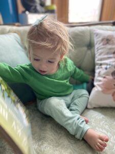 Child in green shirt on couch