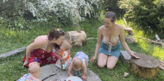 Family of five playing on tree stump