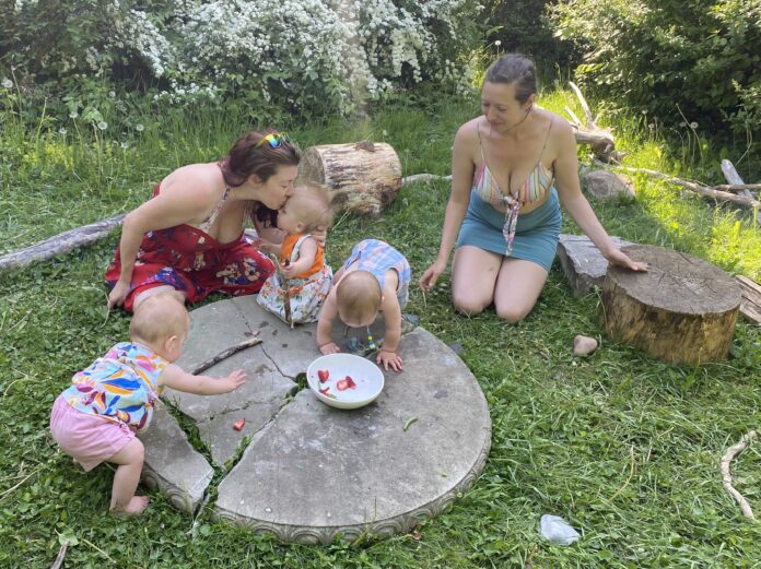 Family of five playing on tree stump