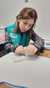 Girl in girl scouts vest practicing STEM