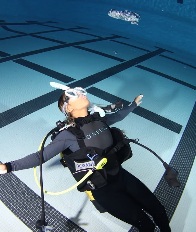 Young scuba diver learning in pool
