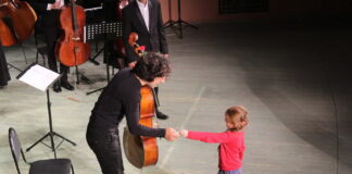 Cello player and child on stage