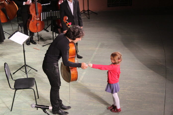 Cello player and child on stage