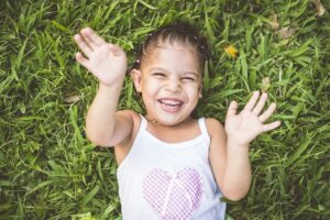 Young girl laying in grass and smiling
