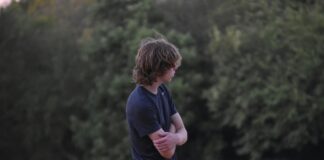 boy with arms crossed outside