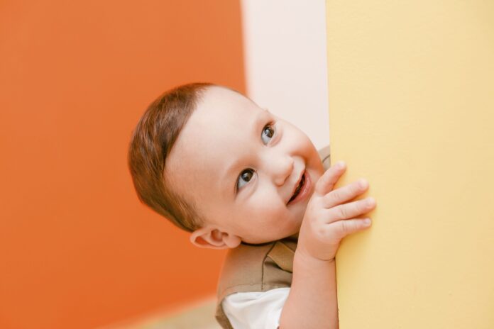 Kid peeking past yellow wall