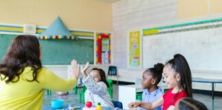 Kids working and high fiving in classroom