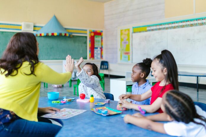 Kids working and high fiving in classroom