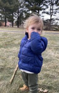Child standing in blue coat