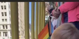 child waving pride flag