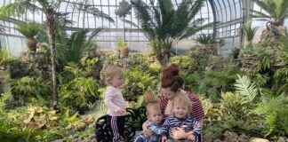 Triplets with mother in area with plants