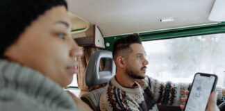 Man and woman in car looking at GPS