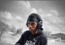 A young person works on their computer while wearing a MMM hoodie